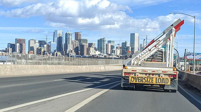 Example of an oversize load truck on the interstate driving into Denver